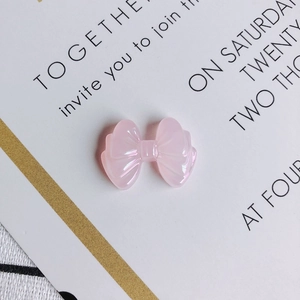 Macro shot of translucent pink resin bow accessory for DIY jewelry and nail art