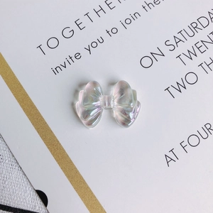 Macro detail of translucent aurora bow-knot resin charms with iridescent finish