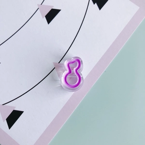 Macro detail of a purple resin music note charm in transparent acrylic for DIY jewelry