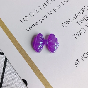 Macro shot of purple translucent resin bow charms with detailed texture for DIY jewelry