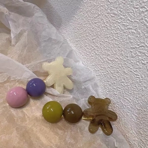 Detailopname van pastelkleurige hars beer haarspelden met kralen in een setting