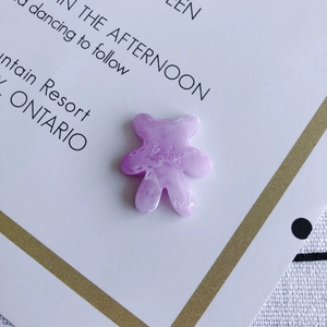 Macro-opname van paarse marmeren harsbeerbedel met Baby-tekst voor DIY-accessoires