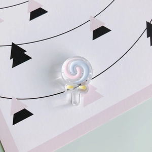 Dettaglio di un ciondolo lecca-lecca in resina con spirale blu rosa e fiocco giallo