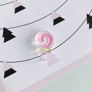 Dettaglio macro del ciondolo lecca-lecca rosa con fiocco giallo per accessori fai-da-te