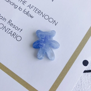 Close-up van doorschijnende blauwe marmeren harsbeertje bedeltje voor DIY sieraden