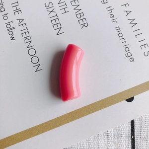 Close-up of bright peach pink curved resin tube bead for DIY jewelry making material