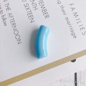 Close-up of light blue curved resin tube bead for DIY jewelry making and necklaces