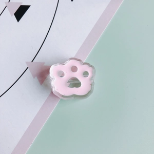 Close-up of pink paw resin brooch showing 3D acrylic layer and metal safety pin back