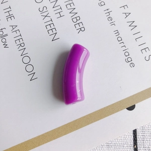 Close-up of polished purple curved tube resin beads for DIY jewelry making and crafting