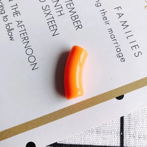 Close-up of a bright orange resin curved tube bead for DIY necklace and bracelet making