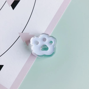 Detailed close-up of a cute acrylic cat paw charm with a white paw pad and green edge