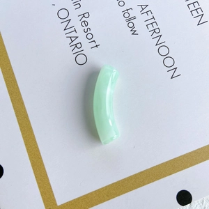 Macro detail of translucent mint green curved tube beads for DIY bracelet making