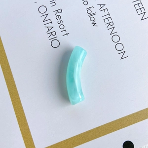 Detail shot of light blue translucent resin curved tube beads for DIY jewelry making