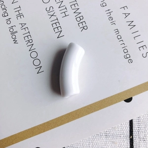 Macro shot of a smooth white curved resin tube bead for DIY necklace and bracelet jewelry