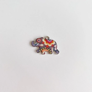 Détail macro d'un pendentif éléphant vintage aux motifs folk colorés pour bijoux DIY