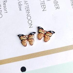 Detail von DIY Schmetterlingsanhängern mit orangefarbener Emaille für die Schmuckherstellung
