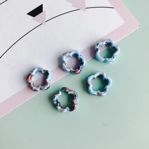 Detalle de cinco cuentas de cerámica con textura de mármol para joyería artesanal