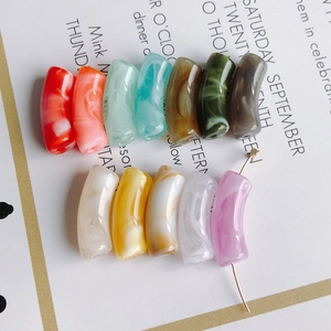 Détails macro de perles acryliques courbées à motif marbre pour la création de bijoux DIY