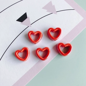 Detailansicht von fünf leuchtend roten hohlen Herz-Keramikperlen für DIY-Schmuck