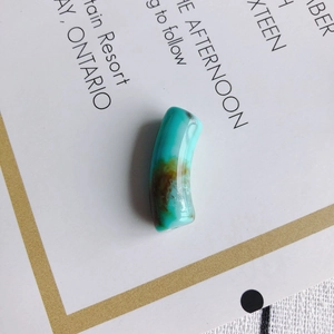 Gros plan sur des perles en acrylique turquoise courbées avec texture minérale pour bijoux DIY