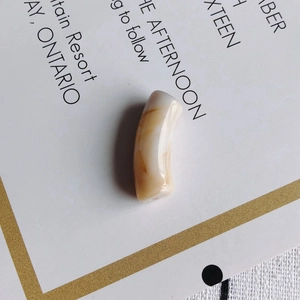 Gros plan de perles tubes en acrylique marbré crème et café pour création de bijoux DIY