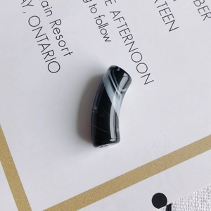 Détail de perles en acrylique courbées avec motif marbre noir et blanc pour bijoux DIY