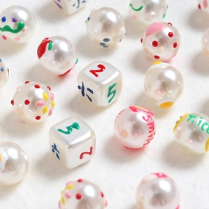 Macro shot of colorful hand-painted DIY beads with pearls, numbers and smiley patterns