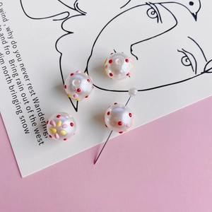 Macro view of colorful dotted faux pearl beads and flower DIY jewelry pins on a stylish card