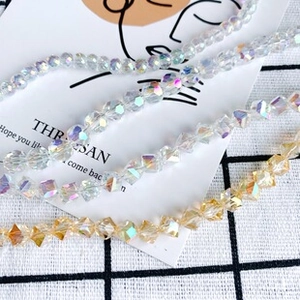Détail macro de perles en cristal facetté irisé et de breloques dorées pour bijoux DIY