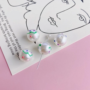 Macro shot of colorful hand-painted round pearl beads with vibrant dotted patterns for DIY