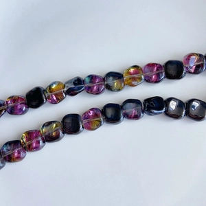 Macro shot of cushion square iridescent glass beads with purple and gold laser coating