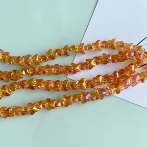 Macro detail of iridescent orange butterfly glass beads for DIY jewelry making