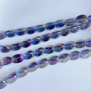 Détail macro de perles ovales en verre aux reflets bleus et violets pour bijoux DIY