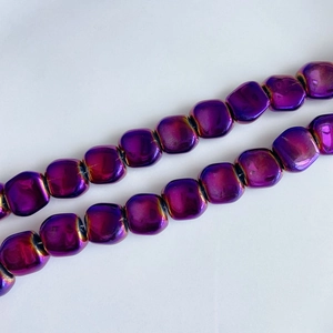 Macro shot of iridescent purple cube glass beads with vibrant laser coating for DIY jewelry