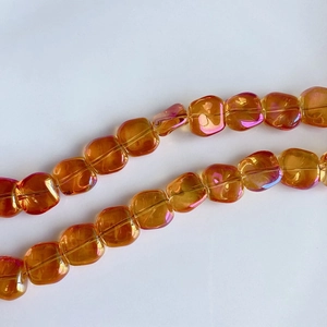 Macro shot of amber iridescent square glass beads with hole for DIY jewelry making