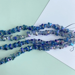 Macro view of iridescent blue butterfly glass beads for DIY jewelry and necklaces