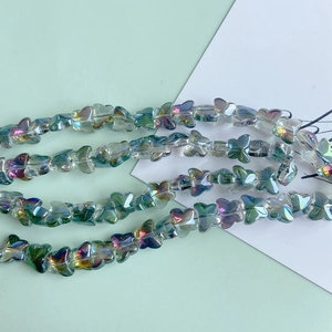 Detailed macro of iridescent glass butterfly beads with AB coating for DIY jewelry