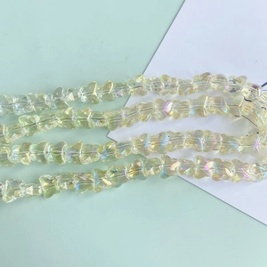 Detailed macro view of champagne butterfly glass beads with iridescent rainbow finish for DIY