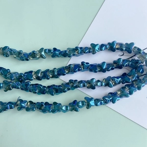 Macro view of blue-purple butterfly glass beads with iridescent AB coating for DIY jewelry