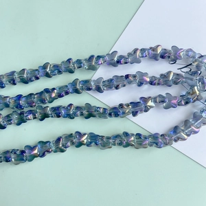 Macro shot of iridescent glass butterfly beads for DIY jewelry with metallic luster