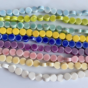 Close-up of flat round glazed ceramic beads in multiple pastel colors for DIY jewelry making