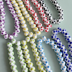 Dettaglio di perle in ceramica colorate a pois per la creazione di gioielli DIY