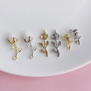 Vista dettagliata di ciondoli a forma di rosa DIY in oro e argento su vassoio ceramico