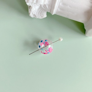 Detail of DIY jewelry bead accessory with hand-painted glass bead and a small pearl accent