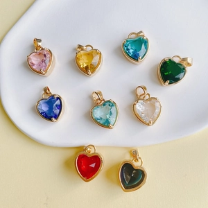 Gros plan de neuf pendentifs cœur en pierres colorées avec bordure en cuivre pour le DIY