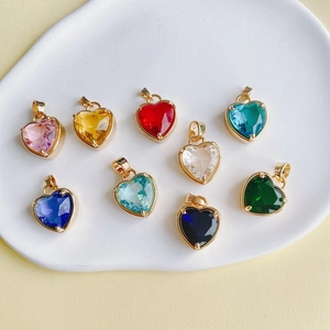Pendentifs cœurs en pierres précieuses colorées avec monture dorée sur plateau