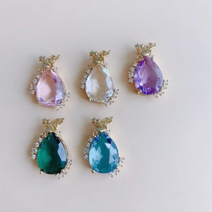Macro view of teardrop pendants with gold angel accents and colorful crystal glass