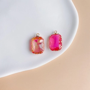 Close-up of geometric rectangular crystal pendants with gold-plated edges in pink shades