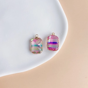 Detail view of rectangular gradient crystal pendants with gold plated edges on ceramic tray