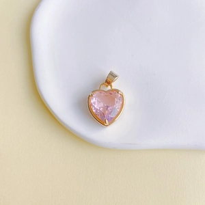 Gros plan d'un pendentif en pierre rose en forme de cœur avec cadre en cuivre doré